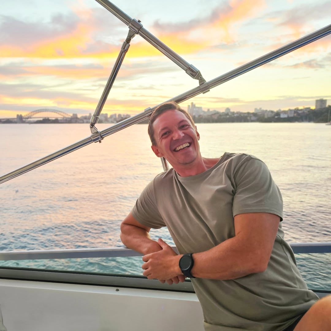 Matt Dawe aboard a boat on Sydney Harbour at sunset